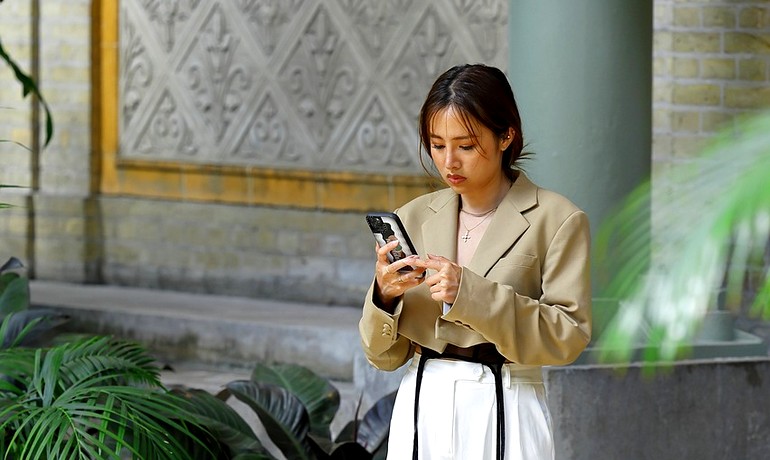 Jeune fille en train de télécharger l'application RM9 sur son smathphone